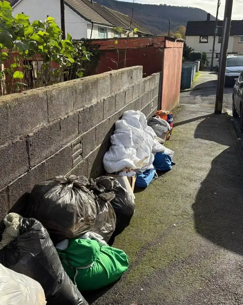 Bags of bedding and household items left outside a property for collection
