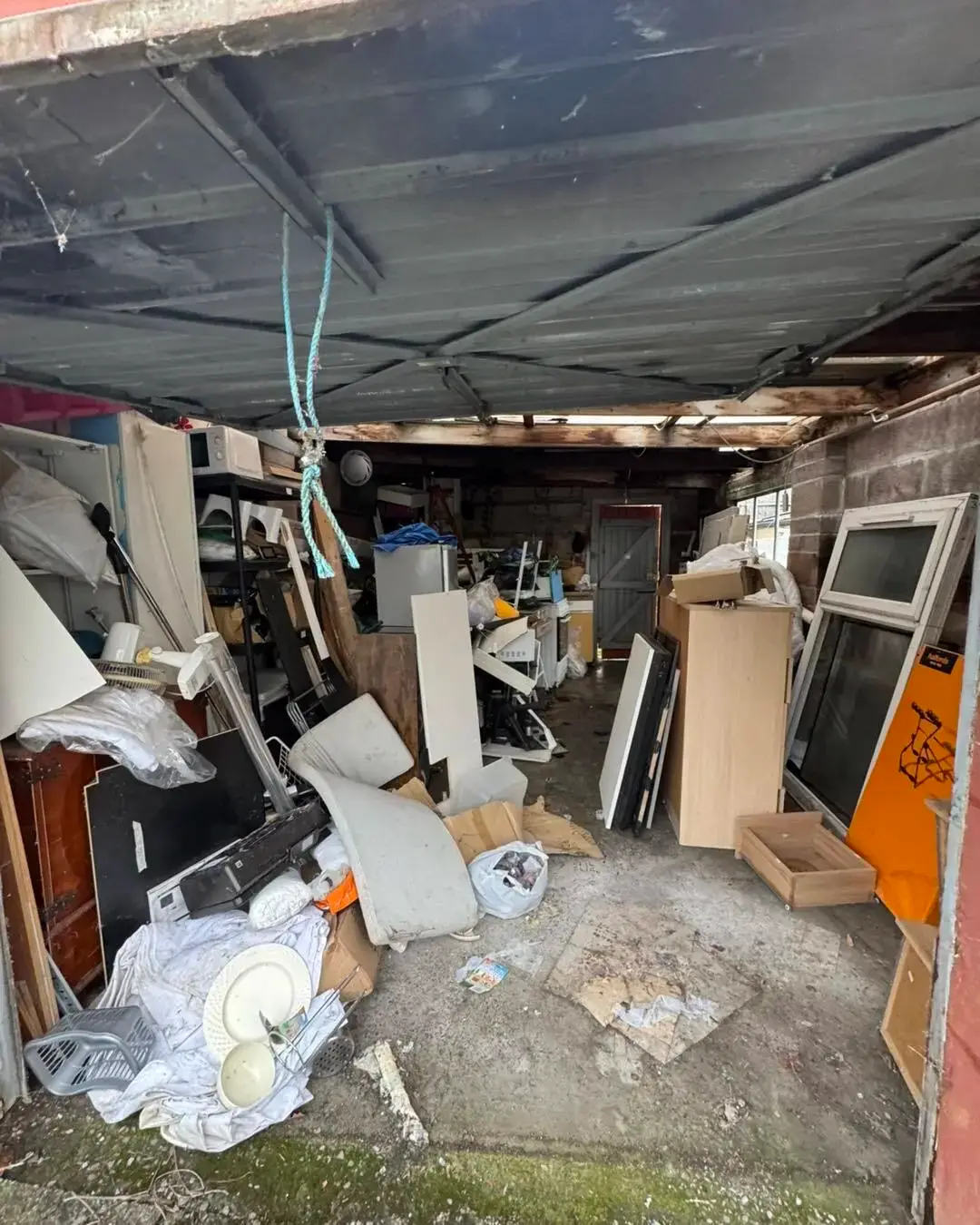 Garage packed with furniture, boxes and clutter before a garage clearance