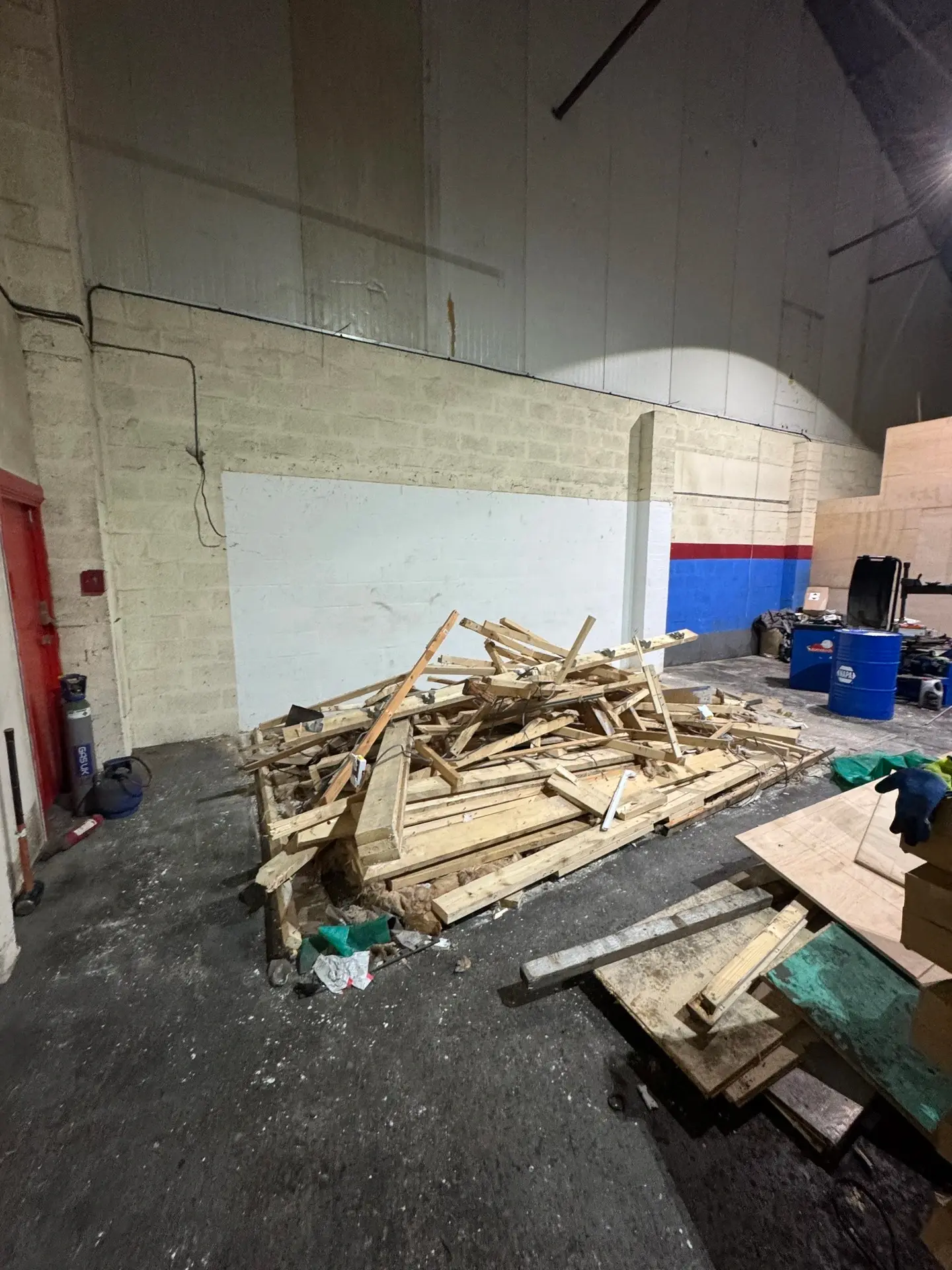 Ripped-out timber framing piled up in a commercial unit